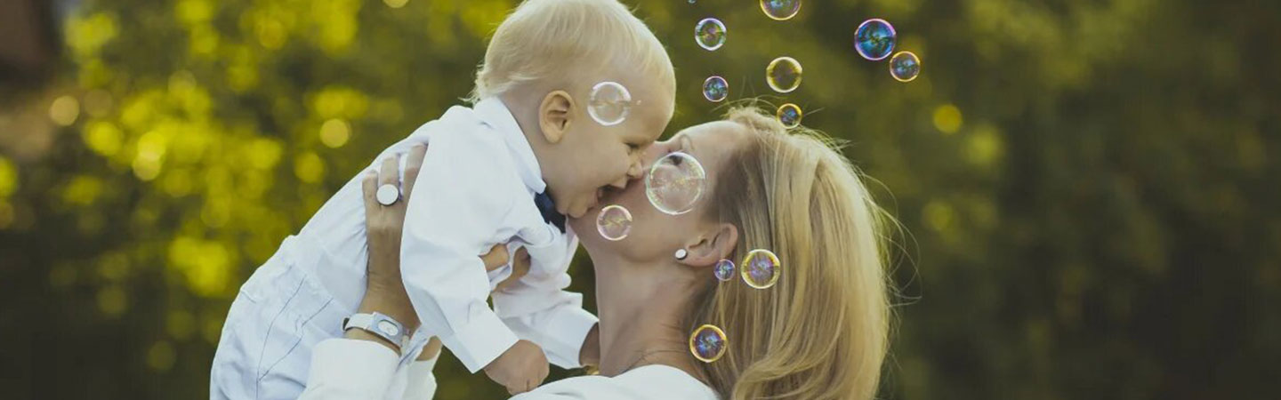 A mother lifting her baby, with bubbles around them